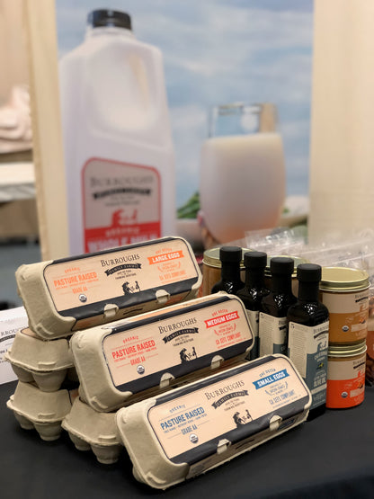 Cartons of pastured eggs at the farm stand alongside bottles of olive oil and milk